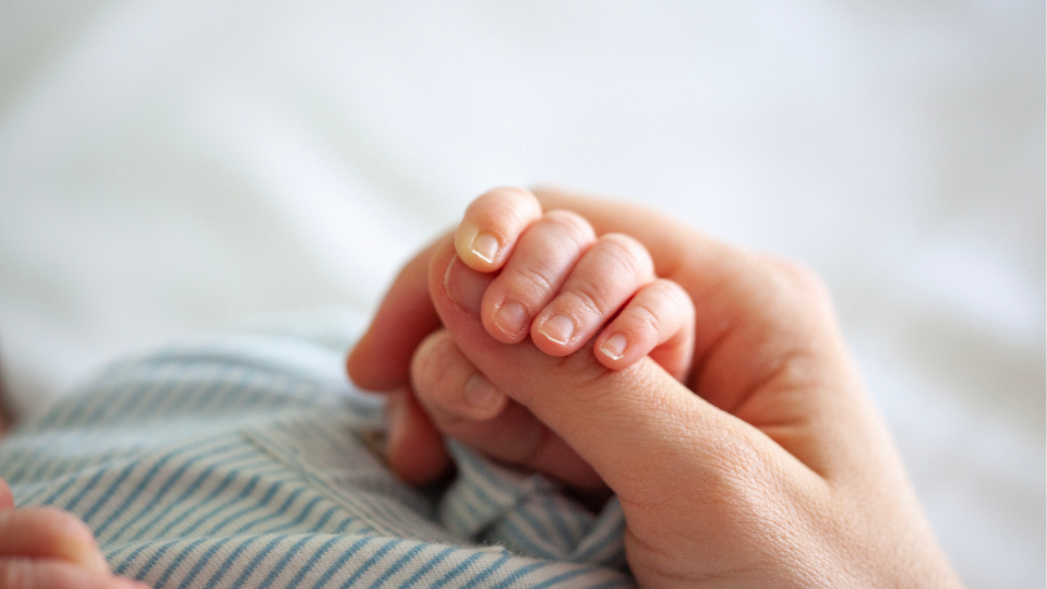 tiny baby's hand clinging to mom's thumb